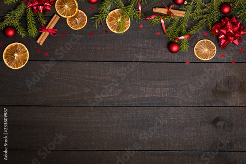 Dark rustic wooden table background with Christmas decoration and fir frame. Top view with free space for copy text