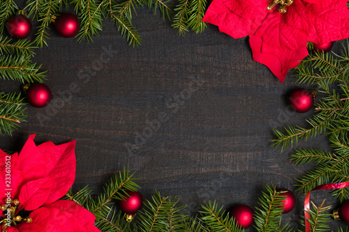 Dark rustic wooden table background with Christmas decoration and fir frame. Top view with free space for copy text