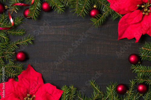 Dark rustic wooden table background with Christmas decoration and fir frame. Top view with free space for copy text