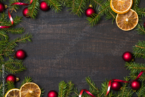 Dark rustic wooden table background with Christmas decoration and fir frame. Top view with free space for copy text