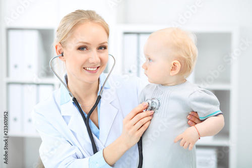 Doctor and patient in hospital. Little girl is being examined by pediatrician with stethoscope. Medicine and health care