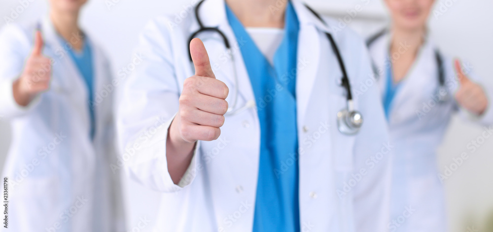 Groupe of medicine doctors show OK sign with thumb up close up. Success and high level service in health care, best treatment and customer loyalty and physical concept. Copy space for advertisement Groupe of medicine doctors show OK sign with thumb up close up. Success and high level service in health care, best treatment and customer loyalty and physical concept. Copy space for advertisement