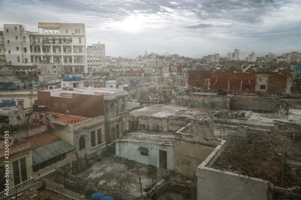 Panoramic view over the rooftops of Havana City in Cuba. The run-down buildings mostly in colonial style provide a special flair for visitors and tourists. Sun stream and lens flare included. Panoramic view over the rooftops of Havana City in Cuba. The run-down buildings mostly in colonial style provide a special flair for visitors and tourists. Sun stream and lens flare included.