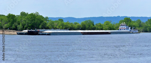 multiple barges being transported on the mississippi river photo