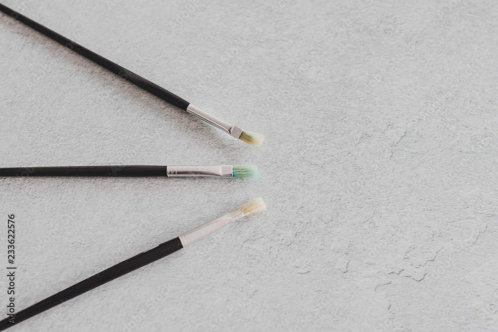 Fototapeta premium paintbrushes on concrete surface with copyspace for your text