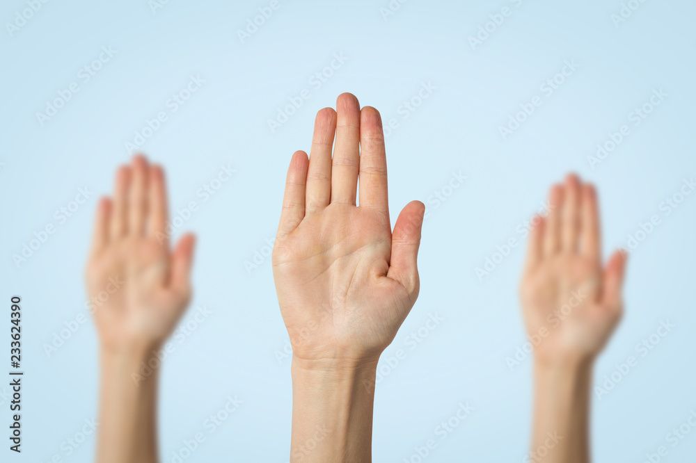 Female palms raised up on a blue background. Stop gesture. Concept stop someone, warn Female palms raised up on a blue background. Stop gesture. Concept stop someone, warn