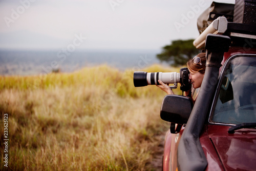Obraz na płótnie Woman photographing while sitting in car at Queen Elisabeth National Park