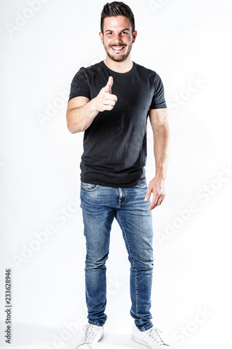 Junger, attraktiver Mann mit Daumen hoch vor weißem Hintergrund © createyour.photo