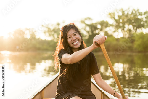 young woman canoeing at sunrise