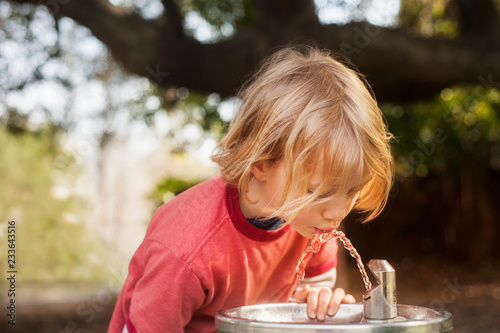 Boy drinking water from fountain