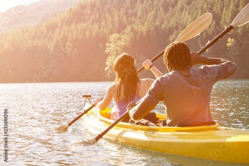 Photos Rear view of couple paddling canoe on river