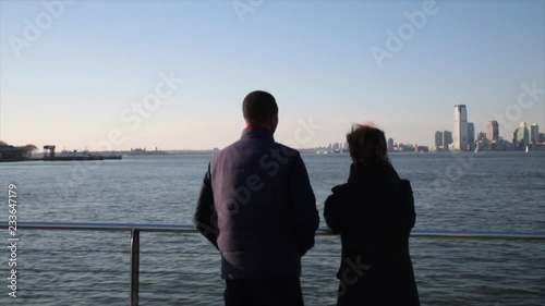 Mixed race couple stand on Hoboken ferry looking out onto the East River in New York