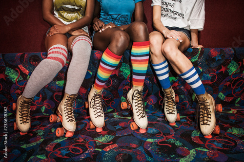 Photos Low section of women wearing roller skates sitting on multi colored sofa
