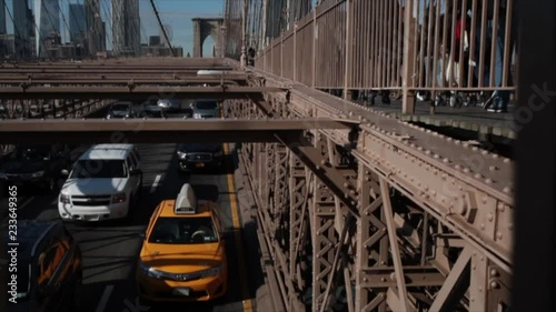 Slow motion slider shot of yellow New York taxi cab on the Brooklyn Bridge