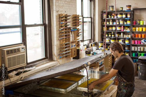 Foto High angle view of worker screen printing in factory