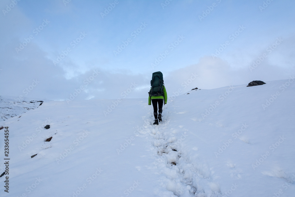  tourist walking on a snowy path with a backpack, Iceland