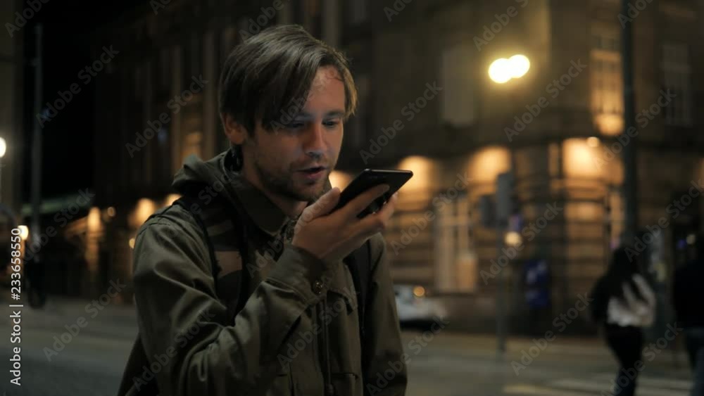 Man voice recognition with smart phone in park night hotel outdoor, student male use message audio helper finder bus stop subway metro station Man voice recognition with smart phone in park night hotel outdoor, student male use message audio helper finder bus stop subway metro station