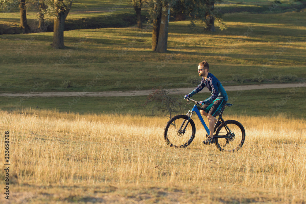 Cyclist in shorts and jersey on a modern carbon hardtail bike with an air suspension fork