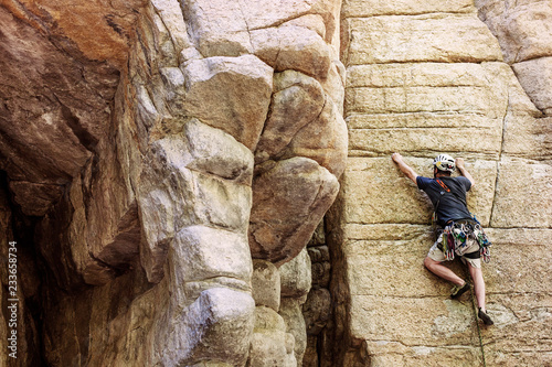 Rear view of rock climber climbing on mountain