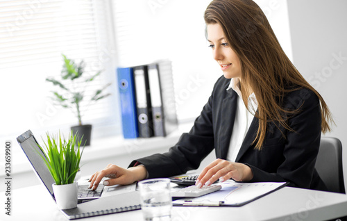 Image of young business woman working on project at office