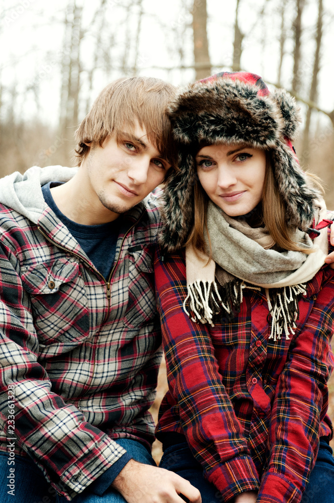 Fototapeta premium Portrait of young couple wearing warm clothing in forest