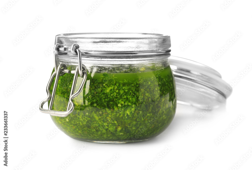 Homemade basil pesto sauce in glass jar on white background Homemade basil pesto sauce in glass jar on white background