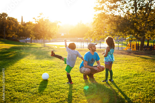 Foto Family playing on grassy field at park during sunset