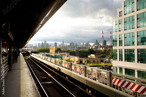 Canvas Print Train arriving at railroad track against building in city