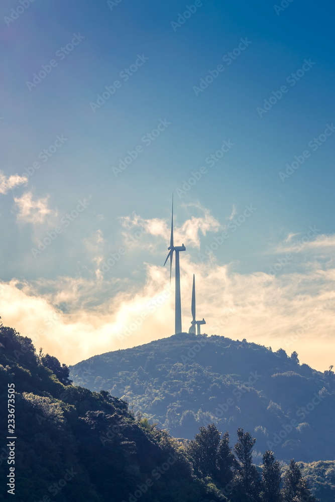 Obraz premium Two wind turbines generating renewable energy in New Zealand.