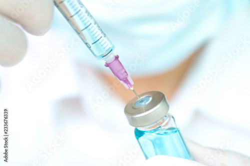 Hand of doctor holding syringe and medicine bottle. Preparing for injection