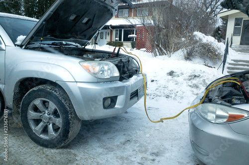 Starting stalled car with jumper cables attached battery to battery from another auto. St Paul Minnesota MN USA