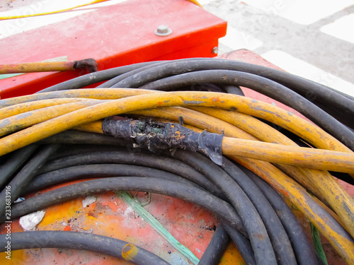 The old and damaged  electrical line, Close up view of damaged, repair by black tape.
