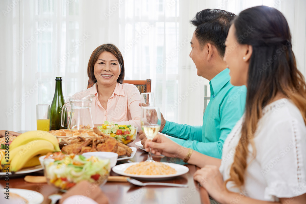 Happy senior Vietnamese woman celebrating birthday with her family