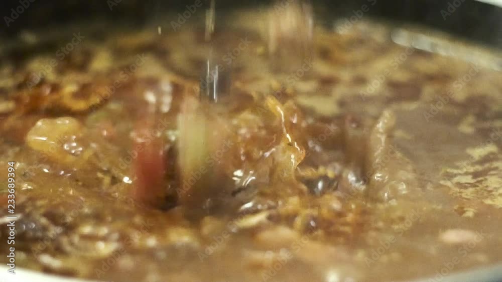 chili is being made for dinner. the food is prepare with black bean, pinto beans pork diced meats such as beef steak. the chef even add tomato celery onions garlic to the stew for added flavor. chili is being made for dinner. the food is prepare with black bean, pinto beans pork diced meats such as beef steak. the chef even add tomato celery onions garlic to the stew for added flavor.