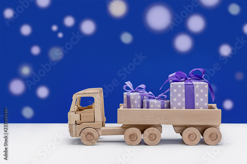 In back of toy car are festive boxes in purple and white polka dots.