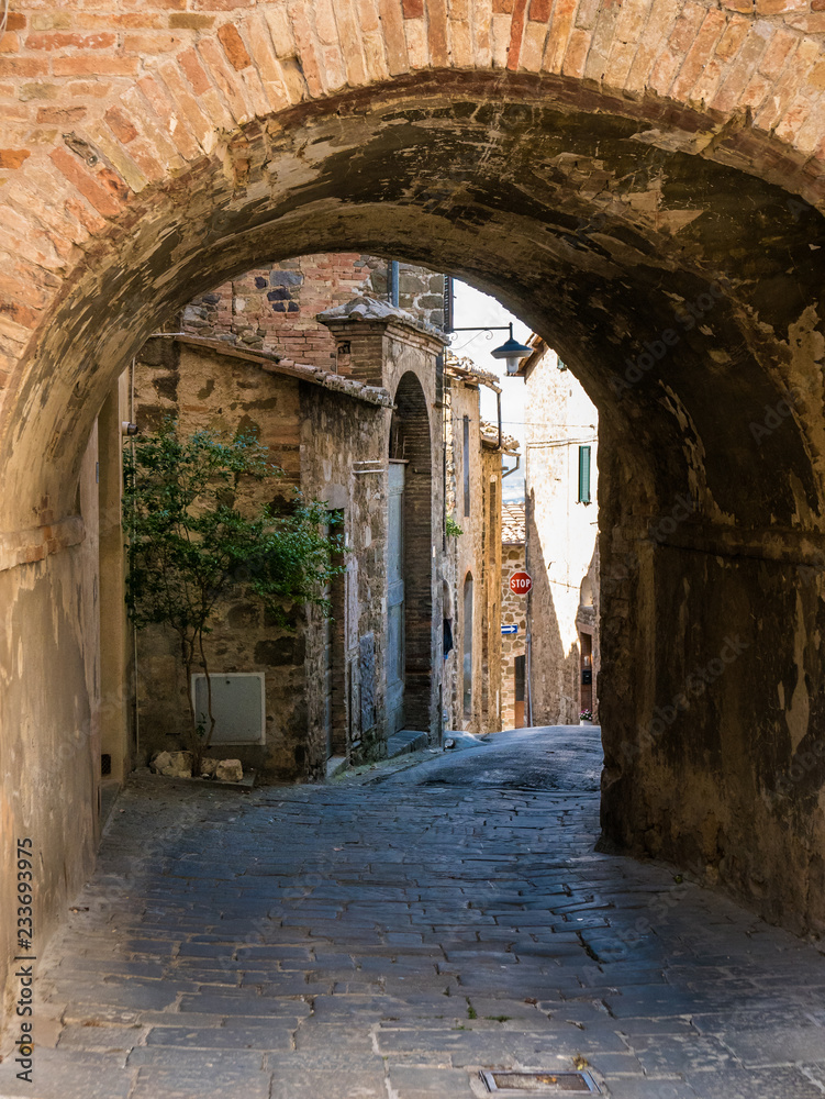 Ancient streets with red bricks and arches in Siena, Tuscany, Italy. Siena is an ancient city whit traditional horse ride called 