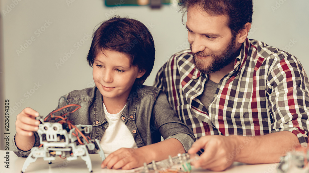 Bearded Father and Son Constructing Robot at Home. Bearded Father and Son Constructing Robot at Home.