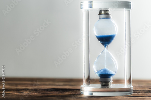 Modern hourglass on wooden background