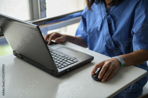 Sick woman using laptop to work on table.