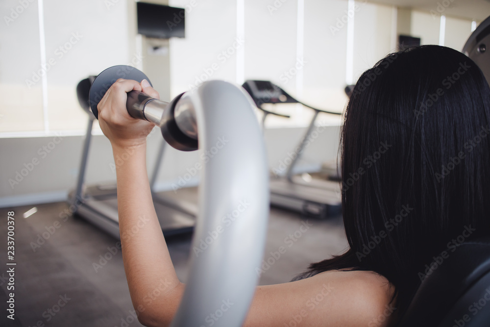 Woman workout on pull down triceps machine in fitness gym. Woman workout on pull down triceps machine in fitness gym.
