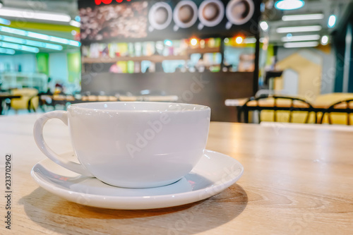 Cup of coffee on wood table in cafe in vintage color mood