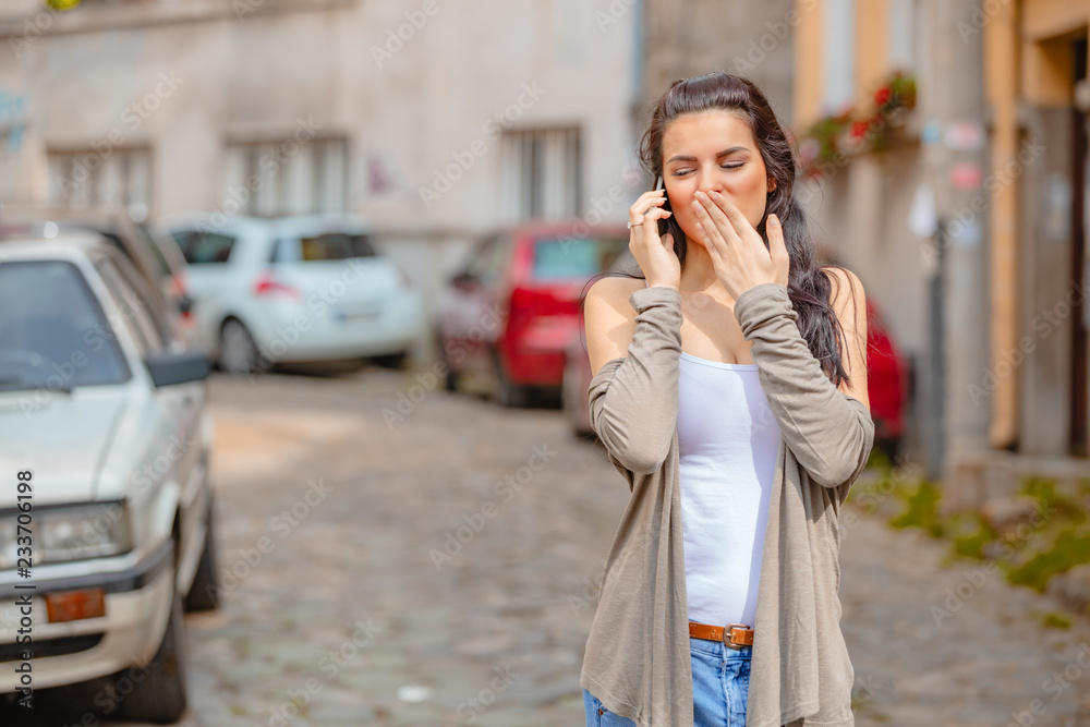 Cute young woman using cellphone in urban surroundings. Cute young woman using cellphone in urban surroundings.