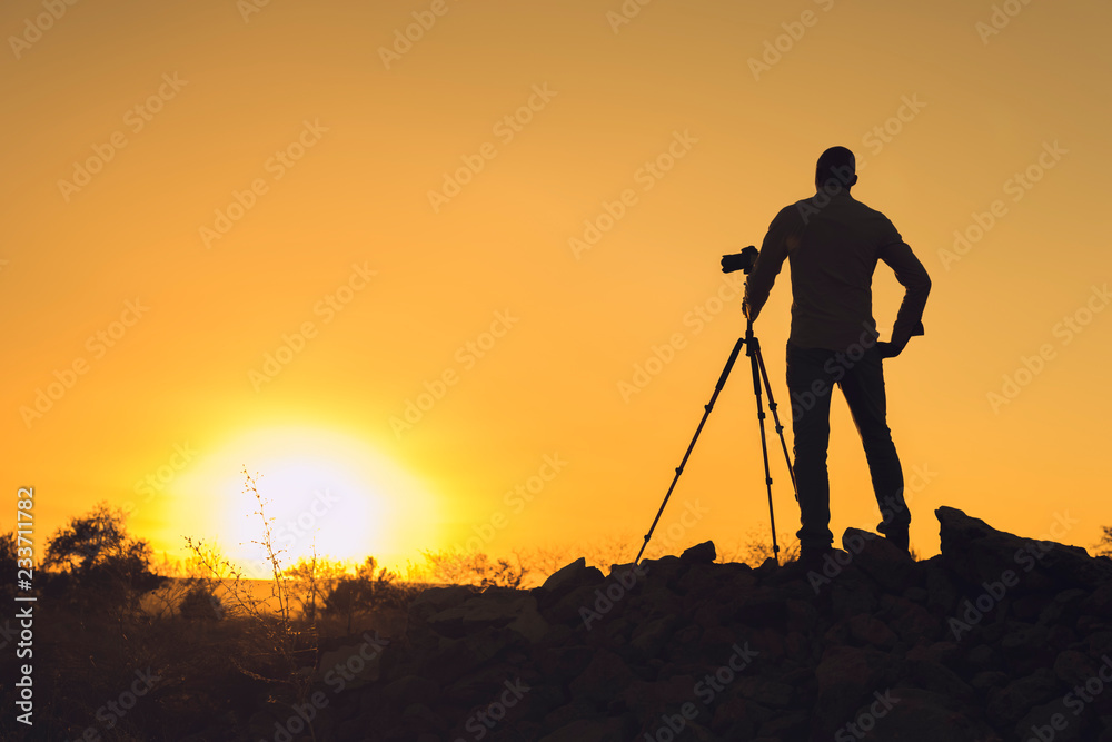 Silhouette of black photographer at sunset