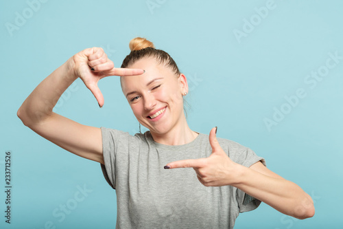 woman pretending to take a photo through her hands creating a frame. photography hobby and leisure.