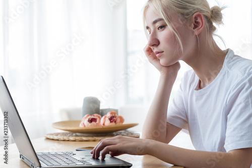 pensive tired woman looking at laptop. writers block and no inspiration concept. photo