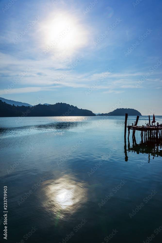 Old wooden bridge on sea with sunny sky Old wooden bridge on sea with sunny sky