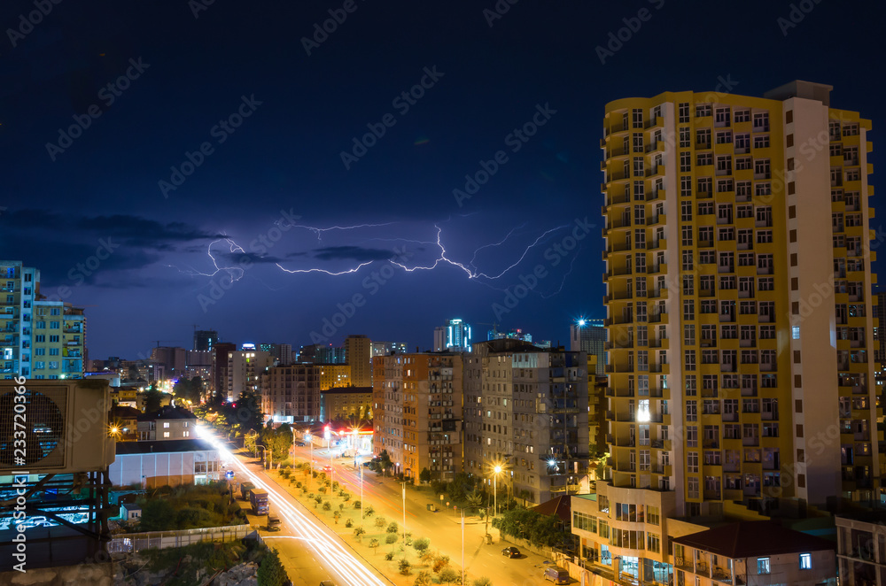 Lightning storm over city in purple light Lightning storm over city in purple light