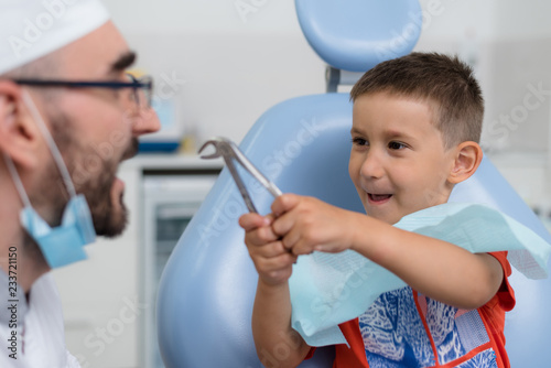 Fototapeta Naklejka Na Ścianę i Meble -  the dentist plays with a small patient so that he is not afraid to treat his teeth