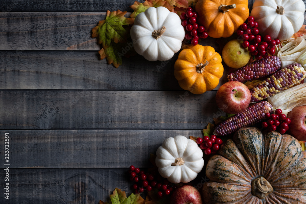 Top view of Autumn maple leaves with Pumpkin, apple, corn and red berries on old wooden background. Thanksgiving day concept. Top view of Autumn maple leaves with Pumpkin, apple, corn and red berries on old wooden background. Thanksgiving day concept.