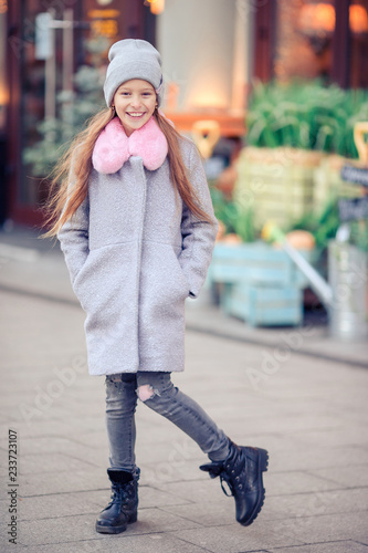 Adorable happy little girl outdoors in european city.